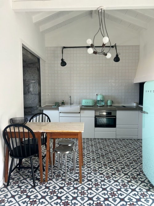 Cozinha moderna com eletrodomésticos turquesas SMEG, armários brancos e mesa de jantar em Cá Por Casa Pico, São Roque do Pico, Açores