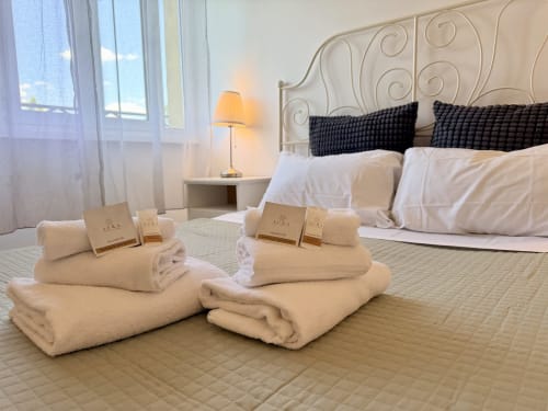 Elegante camera d'hotel a Roma con letto raffinato, asciugamani bianchi freschi, cuscini neri e vista su monumenti storici presso Enjoy Vatican B&B