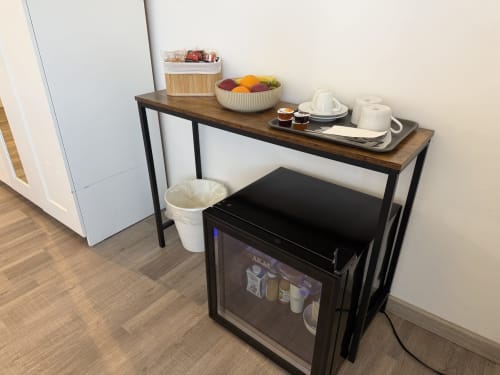 Angolo bevande in camera con minibar, bollitore, ciotola di frutta e stazione caffè all'Enjoy Vatican Rome