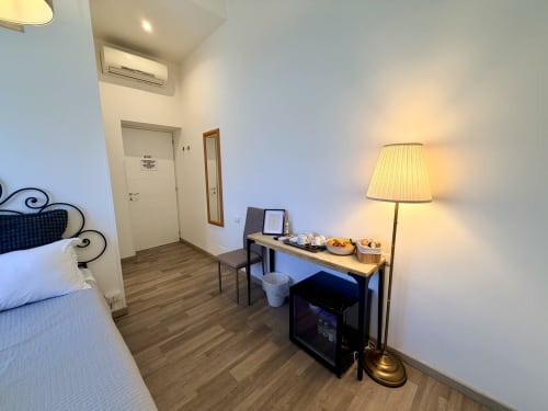 Camera moderna al Enjoy Vatican B&B di Roma con pavimenti in legno, scrivania, lampada e condizionatore