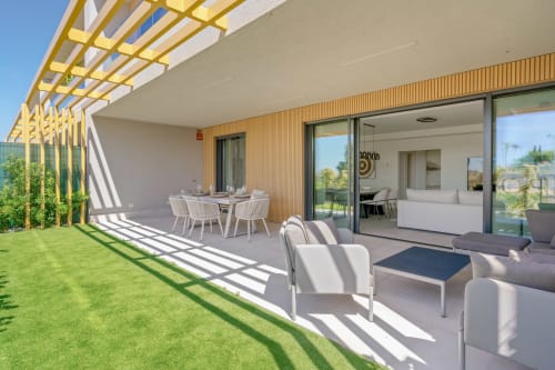 Nowoczesny patio kamienicy w Mijas z jadalnią, strefą wypoczynkową i widokiem na ogród pod żółtą pergolą