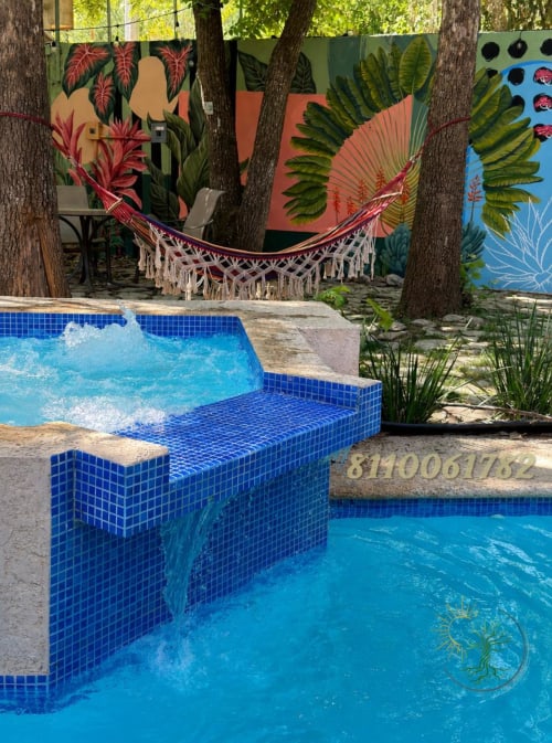 Piscina climatizada con azulejos azules y asientos de banco en el hotel Tierra Cielo & SoLuna en Potrero de Serna, México, con ambiente tropical