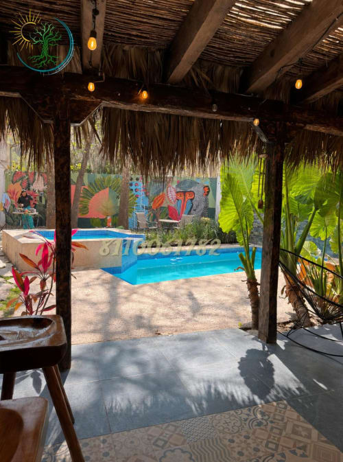 Patio cubierto con letrero de árbol neón con vista a piscina climatizada en el hotel Tierra Cielo & SoLuna, Potrero de Serna, México