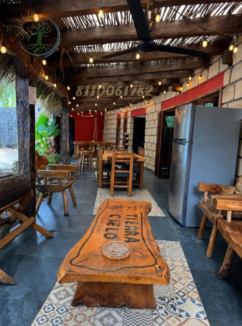 Comedor comunal rústico en Tierra Cielo & SoLuna con muebles de madera, neón y vistas a las montañas en Potrero de