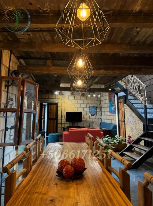 Comedor de apartamento Casona en Tierra Cielo & SoLuna, Potrero de Serna, México con mesa de madera y lámparas colgantes geométricas