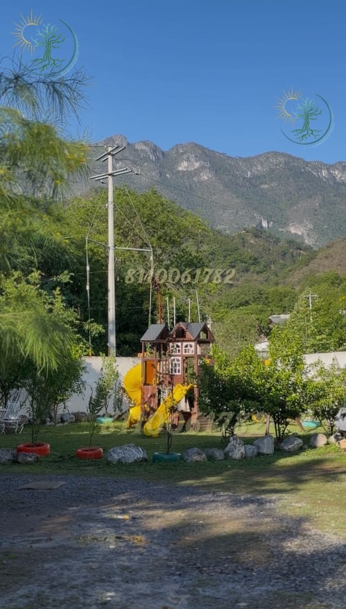 Parque infantil de montaña con tobogán amarillo y cruz en el hotel Tierra Cielo & SoLuna, Potrero de Serna, México