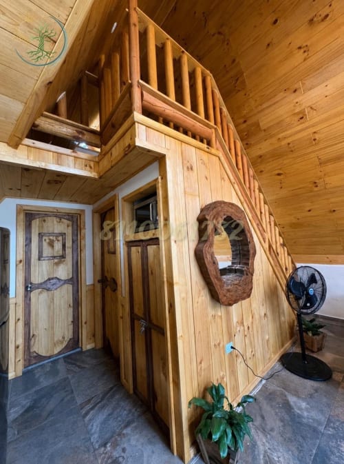 Interior rústico de madera del apartamento Alpina en el hotel Tierra Cielo & SoLuna en Potrero de Serna con loft, espejo tallado y