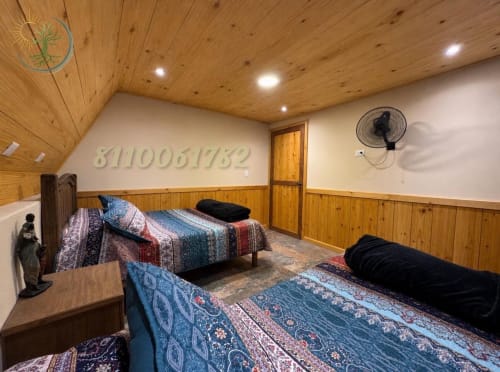 Habitación Alpina en el hotel Tierra Cielo & SoLuna de Potrero de Serna con techo de madera, dos camas, ventilador y vistas a la montaña