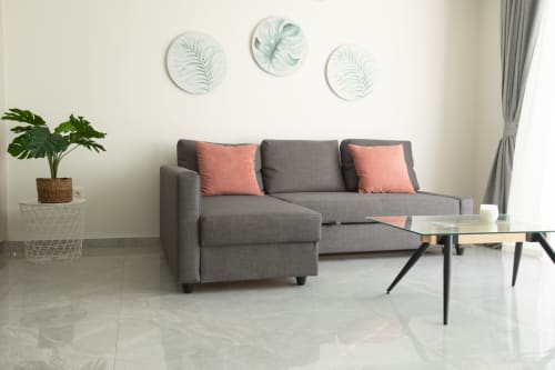 Moderno salón con sofá gris, cojines coral y arte botánico en Villa Gozamena, Fuerteventura