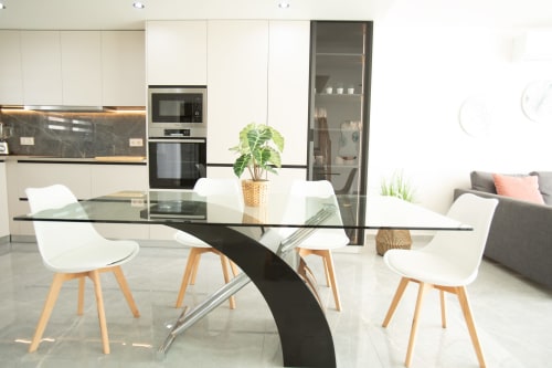 Cocina y comedor de planta abierta en Gozamena con mesa de cristal, sillas blancas y electrodomésticos contemporáneos