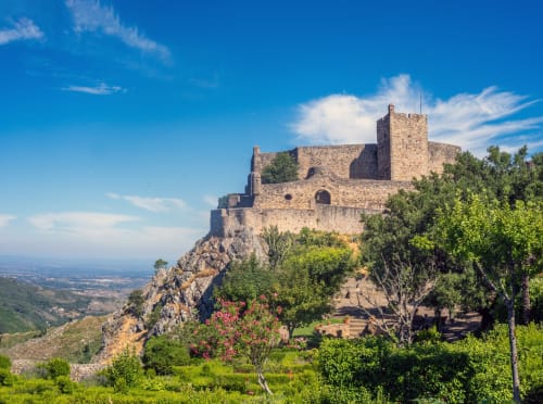 Ruínas de castelo medieval em encosta rochosa com vista para a paisagem de Portalegre, Portugal