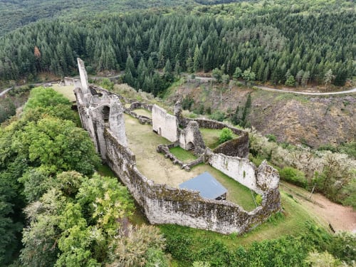 Vue aérienne des ruines du château médiéval entouré d'une forêt verte dense à Rosiers-d'Égletons, France