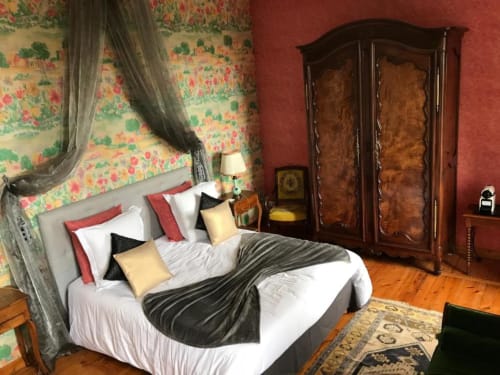 Chambre élégante au Château la Pierre Levée avec papier peint floral, lit à baldaquin et armoire ancienne