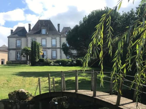 Le manoir de la Pierre Levée avec ses jardins entretenus, pont en bois sur ruisseau et saule pleureur à La Gaubretière, France