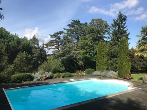 Piscine de l'hôtel La Pierre Levée aux eaux turquoise, terrasse et jardins paysagés à La Gaubretière