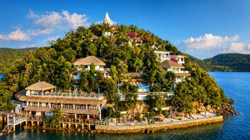 Pearl Bay Villas Palawan luxury beachfront resort on tropical island in Busuanga with thatched-roof villas nestled in lush