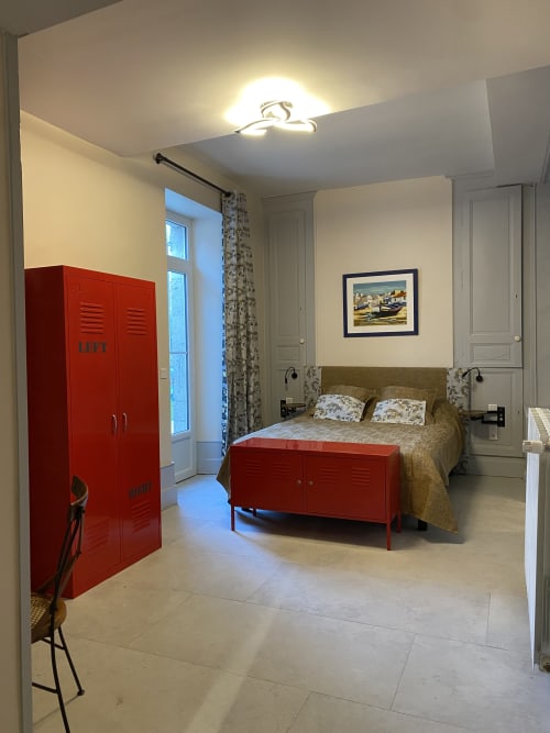 Chambre Caducée au gîte Le Clos Saint Maurin avec casiers rouges, lit olive et vue sur le jardin