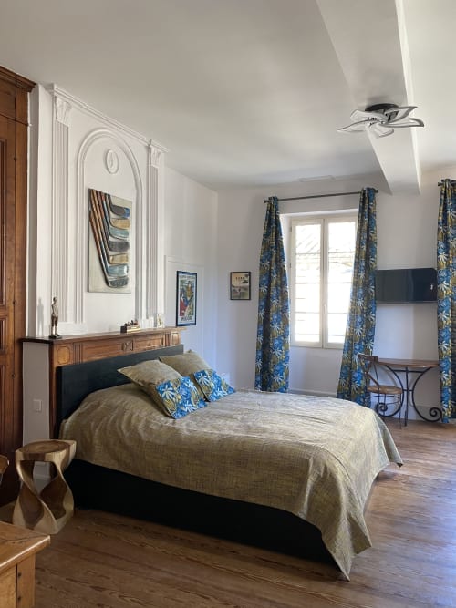 Chambre Green au Clos Saint Maurin : chambre élégante avec lit, rideaux à motifs bleus, mobilier en bois