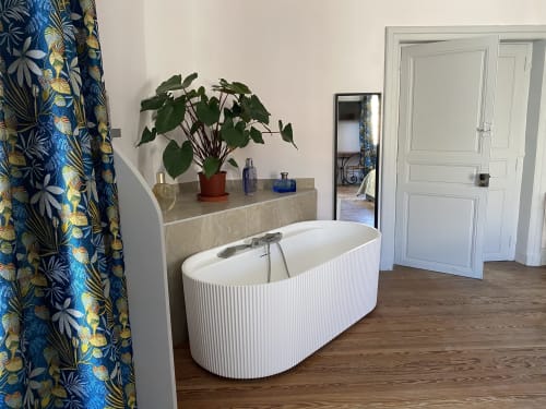 Modern bathtub in Green room at Le Clos Saint Maurin B&B, Saint Maurin, with potted plant and blue patterned curtain