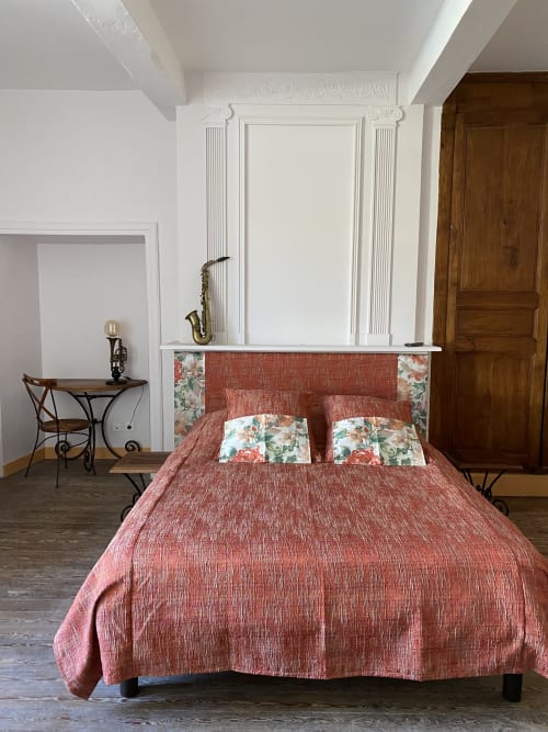 Élégante chambre du B&B Le Clos Saint Maurin à Saint Maurin avec literie terracotta, tête de lit blanche ornementale et ambiance d'époque
