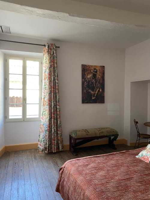 Chambre Adagio bedroom at Le Clos Saint Maurin B&B with floral curtains, wooden floors, and city view in Saint Maurin
