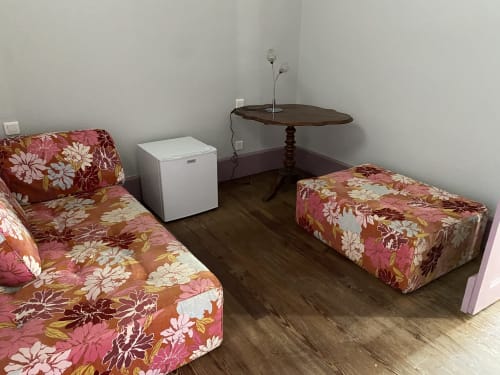 Cozy room at Le Clos Saint Maurin BnB with twin beds, dark wood flooring, white mini fridge, and decorative table with