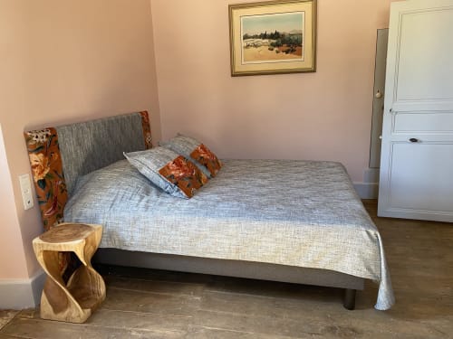Chambre au gîte Le Clos Saint Maurin avec lit gris, table de nuit en bois et tableau paysager à Saint Maurin, France