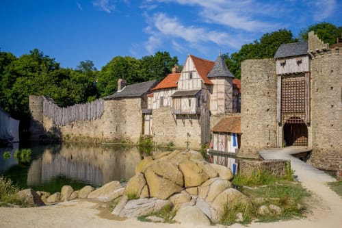 Château médiéval en pierre avec tours surplombant les douves de l'hôtel La Pierre Levée à La Gaubretière, France