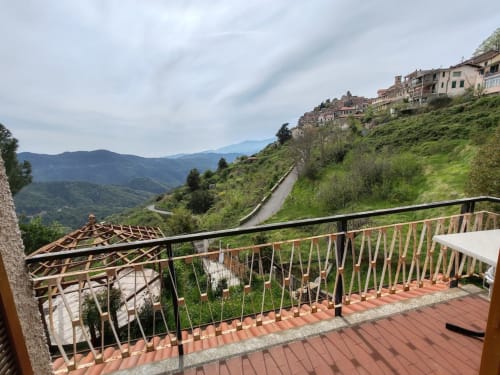 Vue de la terrasse du village de Bajardo en montagne avec route sinueuse et paysage verdoyant à Allegria Affittacamere