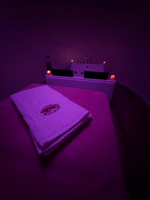 Neon-lit bedroom at Pink-Shell BnB Santiago de Riba-UI with purple glow, bed with spaceship design, and glowing headboard
