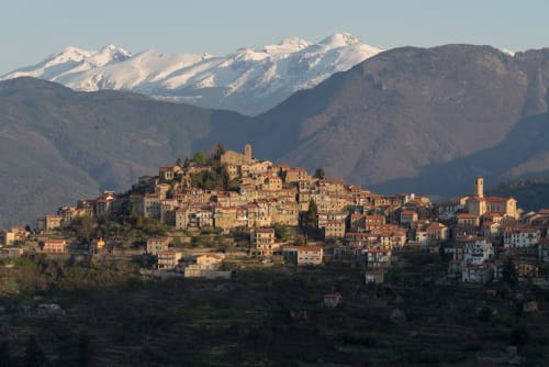 Village perché de Bajardo avec ses bâtiments historiques en pierre et montagnes enneigées en Ligurie, Italie