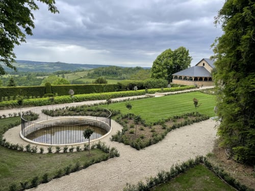Les jardins aménagés du Château de Tharoiseau avec son étang circulaire, paysage de campagne vallonné à Tharoiseau, France