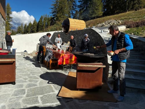 Clients dînant en terrasse au lodge alpin L'Alp'In, La Plagne Tarentaise, avec vue sur les montagnes et tables rustiques en bois