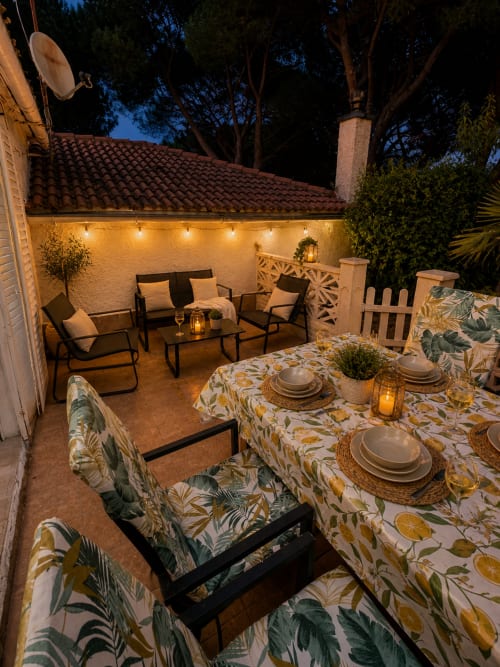 Patio iluminado al atardecer en Las Casitas de Noe con mesa de comedor, área de descanso y vistas a la montaña
