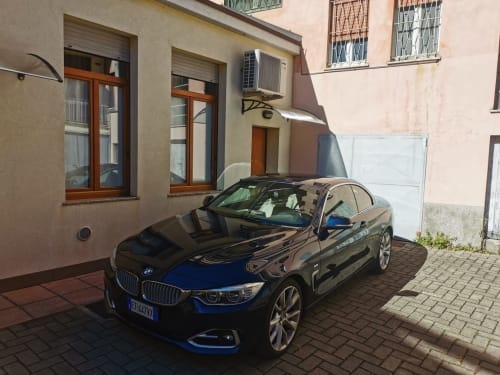 Black BMW parked in courtyard at The Kraken Inn, Bergamo apartment with city view