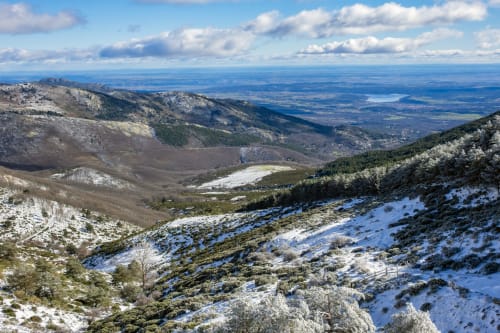 Paisaje montañoso cerca de Collado Villalba con picos nevados, laderas boscosas y vistas del valle en España