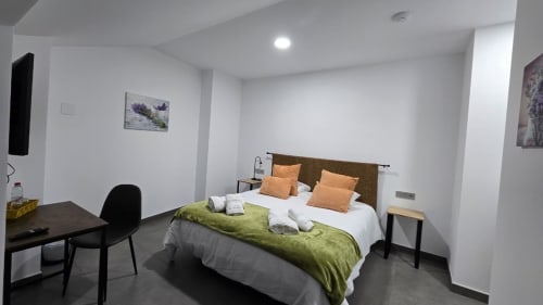 Moderna habitación doble en El Batán Hotel Spa con cama queen, ropa de cama verde, escritorio de trabajo y TV de pantalla plana en Castillo de