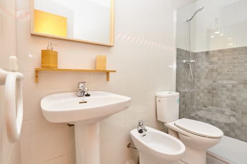 Baño moderno en Experiencias Encant bnb en Calafat con lavabo pedestal, inodoro, bidé y ducha a ras de suelo