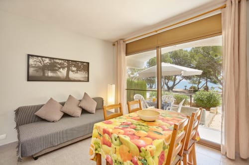 Luminoso comedor en Experiencias Encant B&B de Calafat con terraza con vistas al mar, mantel colorido y jardín costero.