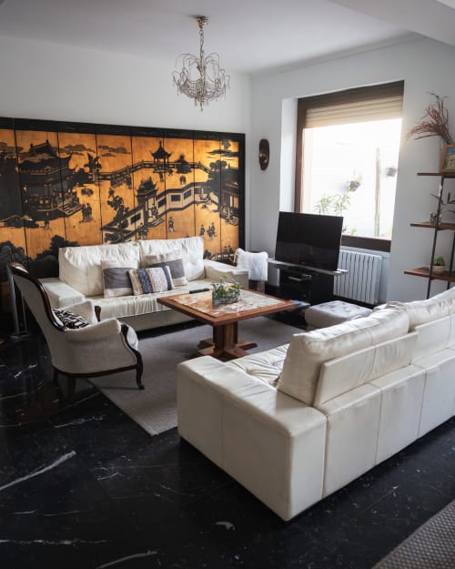 Elegant living room at Casa Señorial Sasueta in San Sebastián with cream sofas, black marble floor, and ornate Asian-inspired