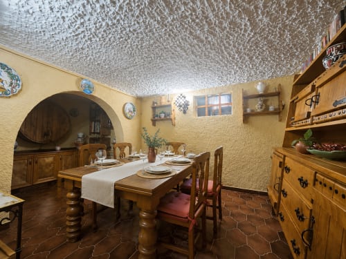 Comedor rústico de Las Casitas de Noe con mesa de madera, paredes amarillas y decoración española tradicional