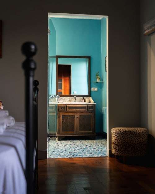 Casa Señorial Sasueta bathroom with turquoise walls, wooden vanity, and decorative floor in San Sebastián