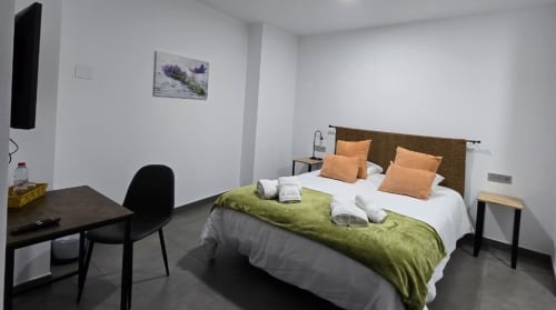 Habitación moderna del Hotel Spa El Batán con cama, escritorio y decoración minimalista en Castillo de Locubín
