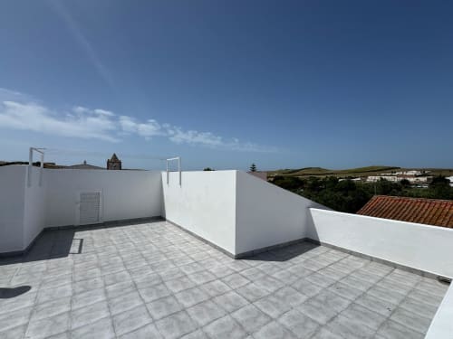Terraço na cobertura da Casa Amarela, Lagos, Portugal com vista da cidade, paredes brancas e piso em azulejos