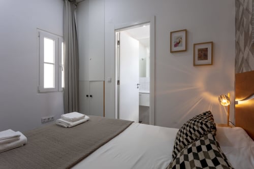 Modern bedroom at Lisbon Poets Inn with double bed, private bathroom, window, and contemporary decor