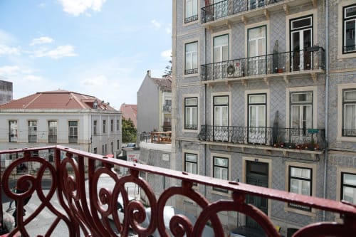 Lisbon Poets Inn hostel overlooks historic Portuguese buildings with blue azulejo tiles and red decorative railings in