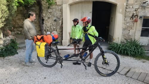 Cyclistes avec leurs vélos devant Le N°9 B&B à Argeliers, France, dans une cour en pierre