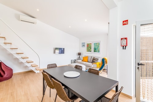 Moderno apartamento Barracuda na Praia do Algarve com zona de refeições, sala de estar, escadas e vista para a piscina