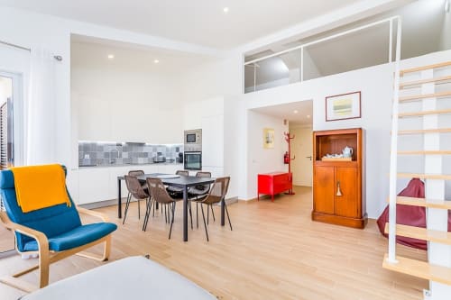 Moderno apartamento Barracuda na Praia do Algarve com cozinha aberta, sala de refeições, poltrona azul e acabamentos em madeira