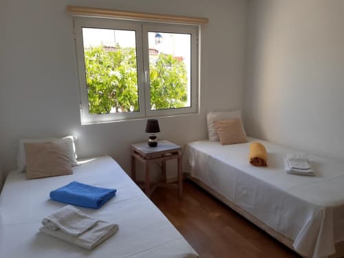 Duas camas individuais em apartamento luminoso de férias na Praia do Algarve com vista para jardim e comodidades modernas